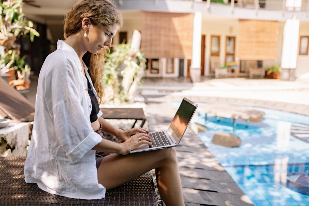 Working during inpatient rehab concept pic shows woman poolside with laptop